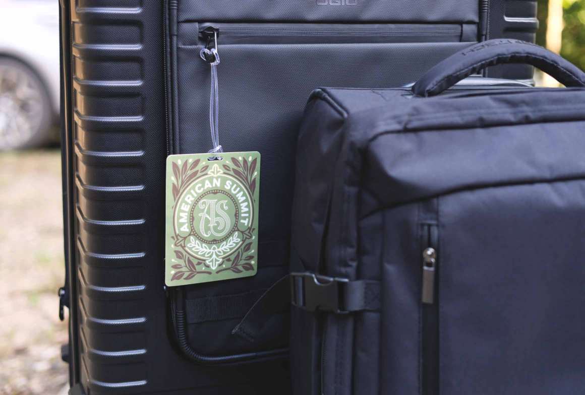 A printed luggage tag hanging from a navy suitcase