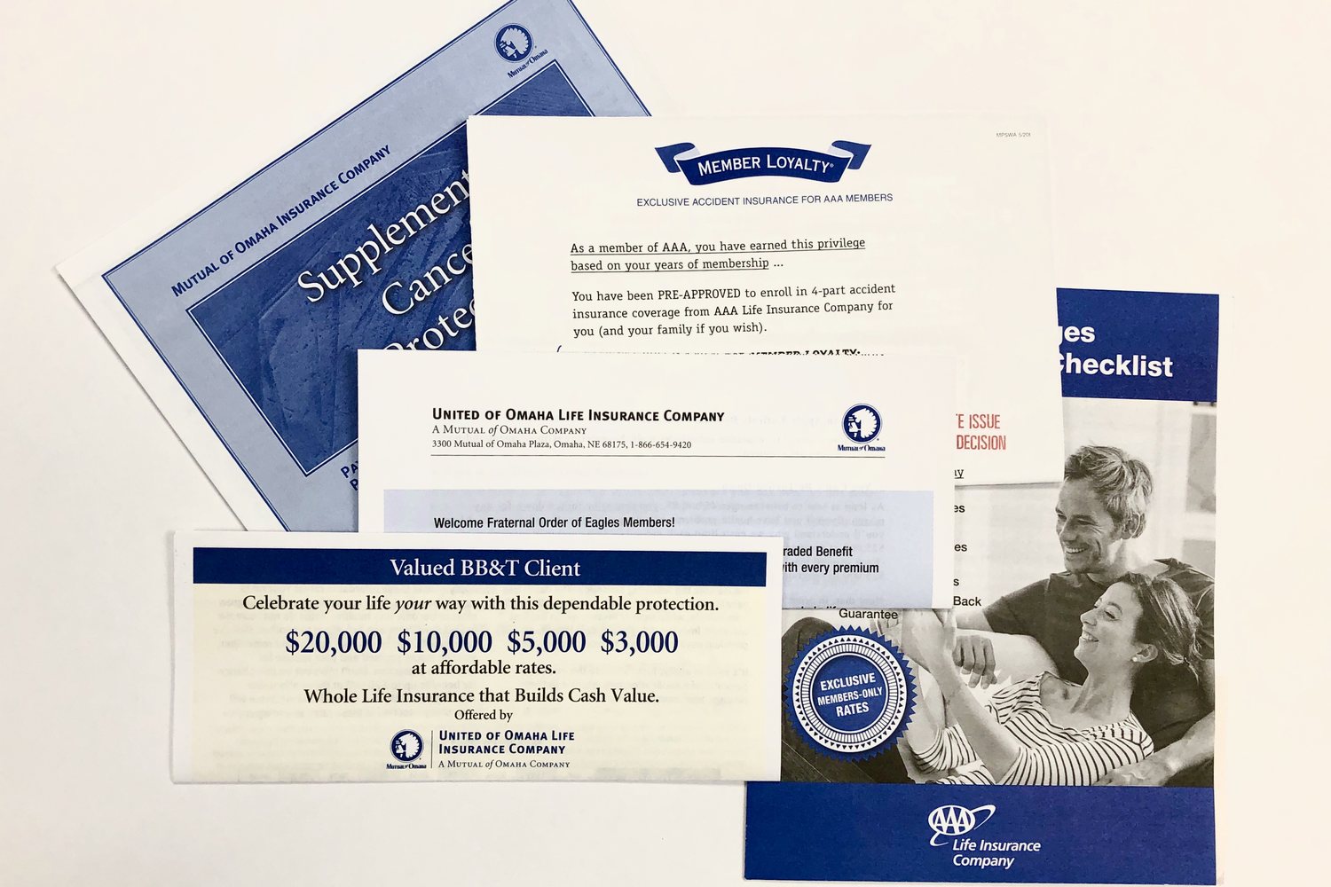 A direct mail acquisition package laid out on a table: offer letters, a reply form, a rate insert and a brochure for member life insurance
